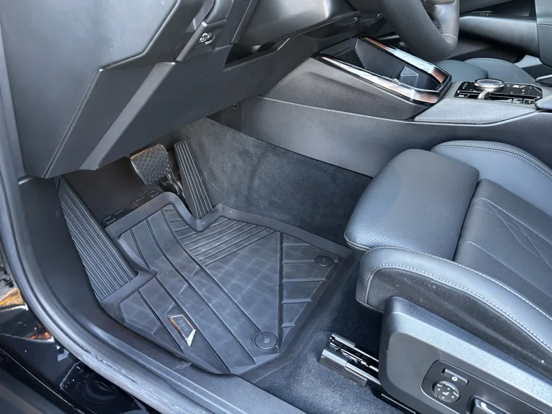 Clean BMW front interior showing the seat, footwell and rubber floor mat